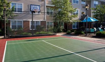 Sonesta ES Suites Chicago Waukegan Gurnee’s basketball court is next to the pool and has a fence beside the hoop.