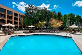 Sonesta Nashville Airport’s outdoor pool has shaded tables and chairs nearby, alongside a row of sun loungers.