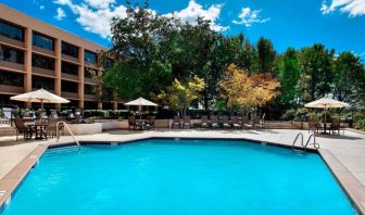 Sonesta Nashville Airport’s outdoor pool has shaded tables and chairs nearby, alongside a row of sun loungers.