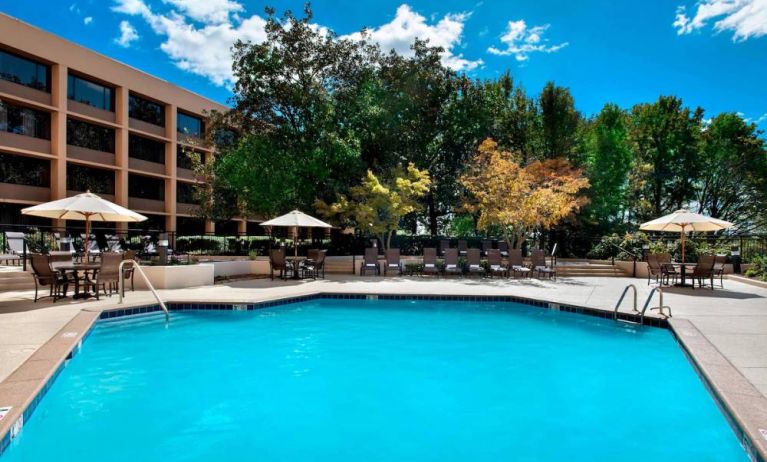 Sonesta Nashville Airport’s outdoor pool has shaded tables and chairs nearby, alongside a row of sun loungers.