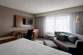 Sonesta Select Tempe Downtown double bed guest room, furnished with TV and sofa, plus workspace desk and chair.