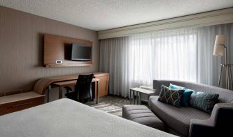 Sonesta Select Tempe Downtown double bed guest room, furnished with TV and sofa, plus workspace desk and chair.