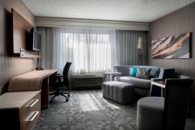 Sonesta Select Tempe Downtown guest room living area, including window, chairs, TV, and sofa.