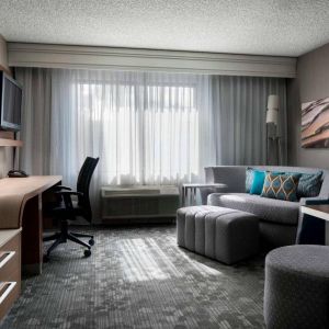 Sonesta Select Tempe Downtown guest room living area, including window, chairs, TV, and sofa.