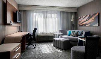 Sonesta Select Tempe Downtown guest room living area, including window, chairs, TV, and sofa.