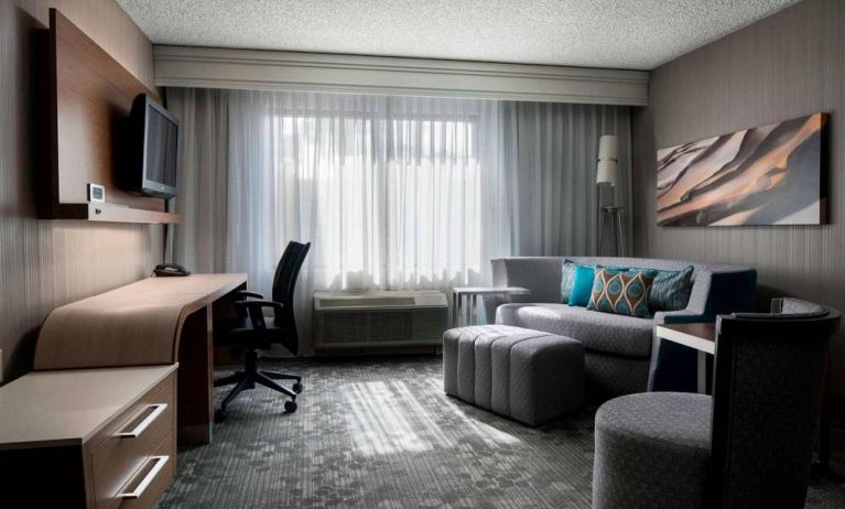 Sonesta Select Tempe Downtown guest room living area, including window, chairs, TV, and sofa.