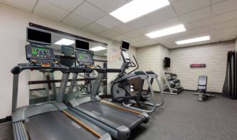 The fitness center in Sonesta Select Tempe Downtown has a wall-mounted TV, free weights, and exercise machines facing a large mirror.