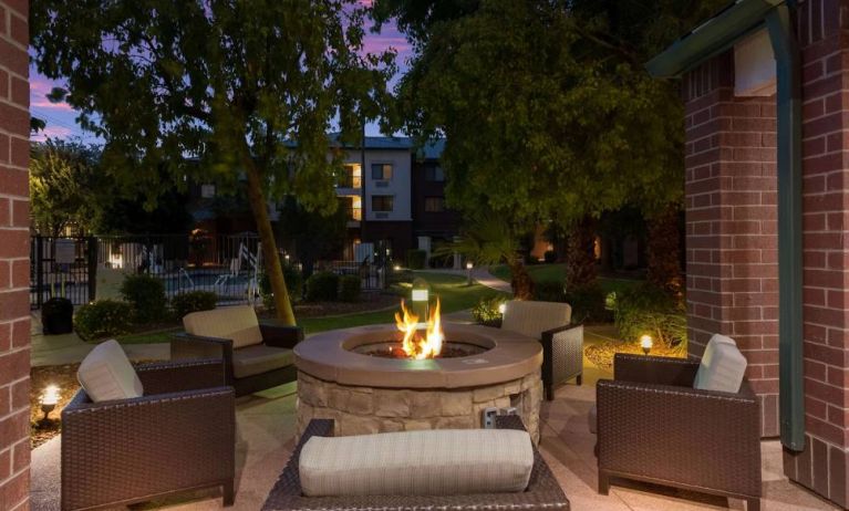 Sonesta Select Tempe Downtown’s fire pit is surrounded by armchairs, with trees nearby and the pool just steps away.