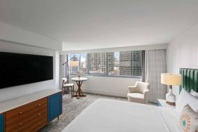 Double bed guest room in Royal Sonesta Chicago Downtown, featuring city views, an armchair, and a large, wall-mounted television.