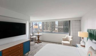 Double bed guest room in Royal Sonesta Chicago Downtown, featuring city views, an armchair, and a large, wall-mounted television.