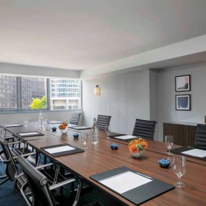 Royal Sonesta Chicago Downtown meeting room, including long table and swivel chairs, with views of the urban landscape.