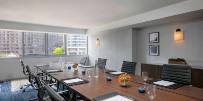 Royal Sonesta Chicago Downtown meeting room, including long table and swivel chairs, with views of the urban landscape.