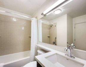 Guest bathroom in Sonesta Simply Suites Phoenix Tempe, including shower, bath, lavatory, and sink.