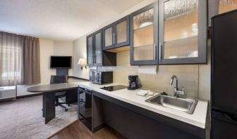 Sonesta Simply Suites Phoenix Tempe guest room kitchen, with hob, microwave, oven, and fridge-freezer, and a nearby TV.