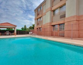 The outdoor pool at Sonesta Simply Suites Phoenix Tempe has sun loungers by the side, and is close to the gazebo and barbecue facilities.