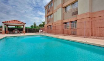 The outdoor pool at Sonesta Simply Suites Phoenix Tempe has sun loungers by the side, and is close to the gazebo and barbecue facilities.