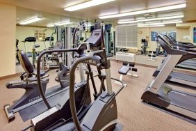 Sonesta Simply Suites Phoenix Tempe’s fitness center has a mirrored wall and a range of exercise equipment.