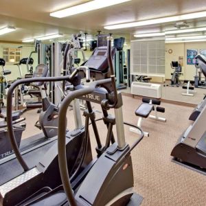 Sonesta Simply Suites Phoenix Tempe’s fitness center has a mirrored wall and a range of exercise equipment.