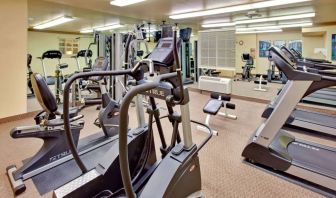 Sonesta Simply Suites Phoenix Tempe’s fitness center has a mirrored wall and a range of exercise equipment.