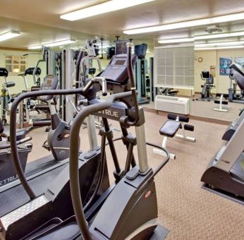 Sonesta Simply Suites Phoenix Tempe’s fitness center has a mirrored wall and a range of exercise equipment.