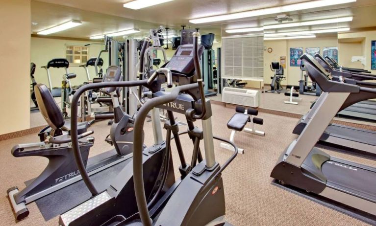 Sonesta Simply Suites Phoenix Tempe’s fitness center has a mirrored wall and a range of exercise equipment.