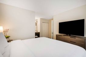 Sonesta ES Suites Denver South - Park Meadows double bed guest room, including bedside lamp and large TV.