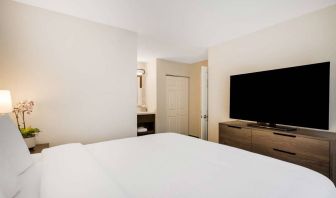 Sonesta ES Suites Denver South - Park Meadows double bed guest room, including bedside lamp and large TV.