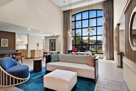 The lobby lounge in Sonesta ES Suites Denver South - Park Meadows has tables and chairs, plus sofa seating, a high ceiling and large windows for plenty of natural light.