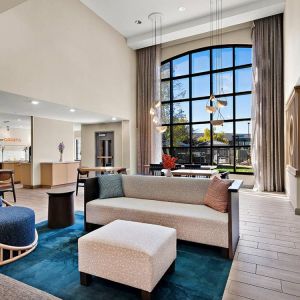 The lobby lounge in Sonesta ES Suites Denver South - Park Meadows has tables and chairs, plus sofa seating, a high ceiling and large windows for plenty of natural light.