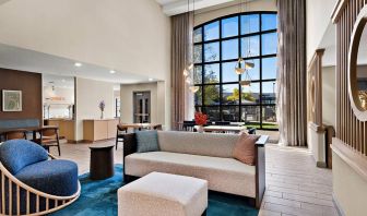 The lobby lounge in Sonesta ES Suites Denver South - Park Meadows has tables and chairs, plus sofa seating, a high ceiling and large windows for plenty of natural light.