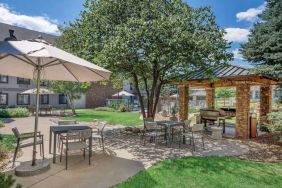 Sonesta ES Suites Denver South - Park Meadows’ patio includes shaded tables and chairs, trees, and a gazebo with barbecue facilities.