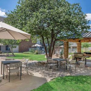 Sonesta ES Suites Denver South - Park Meadows’ patio includes shaded tables and chairs, trees, and a gazebo with barbecue facilities.