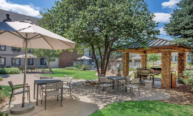 Sonesta ES Suites Denver South - Park Meadows’ patio includes shaded tables and chairs, trees, and a gazebo with barbecue facilities.