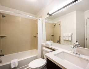 Guest bathroom in Sonesta Simply Suites Miami Airport Doral, featuring sink, mirror, lavatory, bath, and shower.