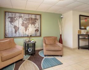 The hotel’s lobby is furnished with a pair of armchairs, a coffee table, and an artistic map of the world on the wall.