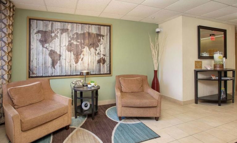 The hotel’s lobby is furnished with a pair of armchairs, a coffee table, and an artistic map of the world on the wall.