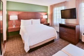 Double bed guest room in Sonesta ES Suites Fort Lauderdale Plantation, featuring bedside lamps, windows, and a large TV.