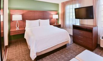 Double bed guest room in Sonesta ES Suites Fort Lauderdale Plantation, featuring bedside lamps, windows, and a large TV.