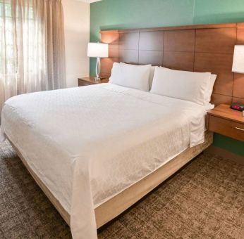 Double bed guest room in Sonesta ES Suites Fort Lauderdale Plantation, including bedside lamps and a window.