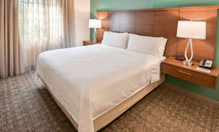 Double bed guest room in Sonesta ES Suites Fort Lauderdale Plantation, including bedside lamps and a window.