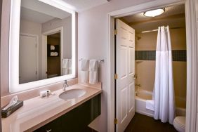 Guest bathroom in Sonesta ES Suites Fort Lauderdale Plantation, with shower-equipped bath, lavatory, mirror, and sink.