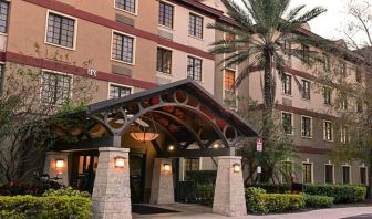 The hotel’s exterior features a covered entrance beside which there’s extensive greenery, including a towering palm tree.