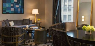 Lounge within a guest room of The Allegro Royal Sonesta Hotel Chicago Loop, including sofa, armchairs, coffee tables, and a window.