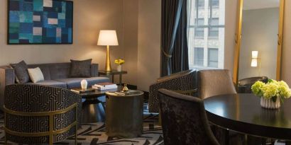 Lounge within a guest room of The Allegro Royal Sonesta Hotel Chicago Loop, including sofa, armchairs, coffee tables, and a window.