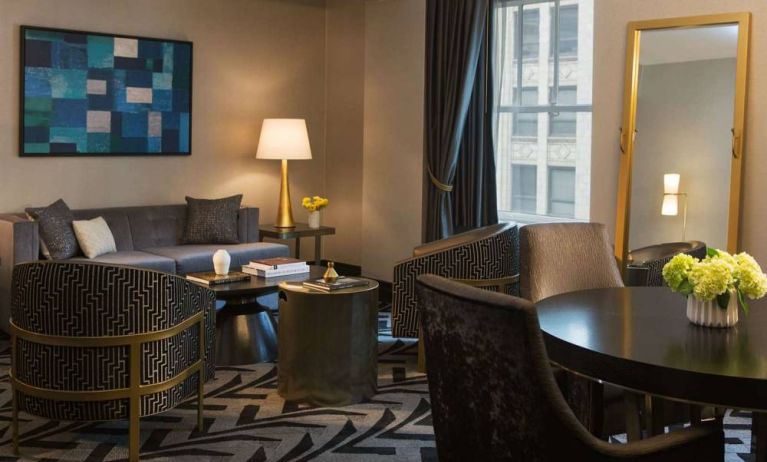 Lounge within a guest room of The Allegro Royal Sonesta Hotel Chicago Loop, including sofa, armchairs, coffee tables, and a window.