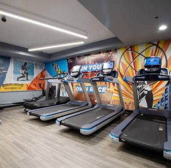 The fitness center in The Allegro Royal Sonesta Hotel Chicago Loop has assorted types of exercise machine and motivational artwork on the wall.