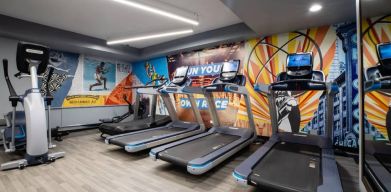 The fitness center in The Allegro Royal Sonesta Hotel Chicago Loop has assorted types of exercise machine and motivational artwork on the wall.