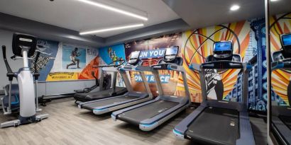 The fitness center in The Allegro Royal Sonesta Hotel Chicago Loop has assorted types of exercise machine and motivational artwork on the wall.