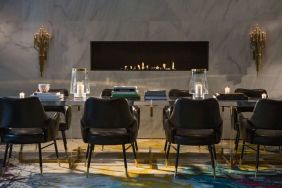 The Allegro Royal Sonesta Hotel Chicago Loop’s lobby lounge includes a table, comfortable seating, and a fireplace.