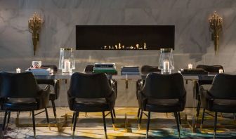 The Allegro Royal Sonesta Hotel Chicago Loop’s lobby lounge includes a table, comfortable seating, and a fireplace.